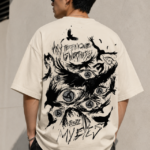 Man wearing Luri Before My Eyes anime graphic oversized t-shirt — cream unisex tee with "Before My Eyes" chest print in grunge script, front view