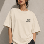 Woman wearing Luri Before My Eyes anime graphic oversized t-shirt — cream unisex tee with small "Before My Eyes" grunge chest print, clean front view, relaxed boxy oversized fit