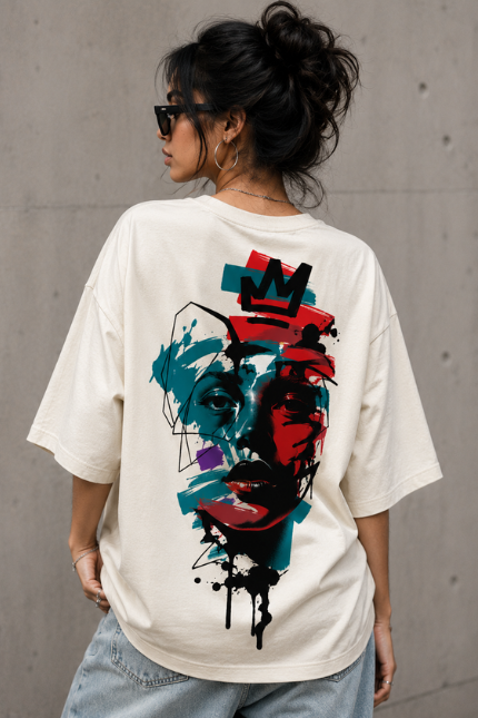 Woman wearing Luri Crowned Face graphic oversized t-shirt — cream unisex street art tee with neo-expressionist crowned face print in teal, red and black, back view