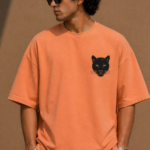 Man wearing Luri Silent Panther oversized t-shirt in terracotta — front view with black panther face chest print, premium unisex 260 GSM Supima Cotton, structured boxy oversized fit